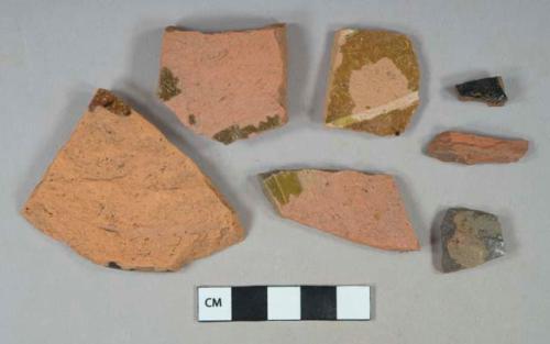 Brown slip decorated redware vessel body and base fragments