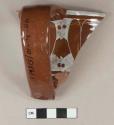 Brown glazed, white transfer printed redware rim and handle sherd