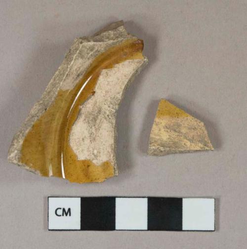 Yellow lead glazed earthenware vessel body and base fragments, buff paste