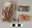 Dark red-brown lead glazed redware vessel body, base, and handle fragments