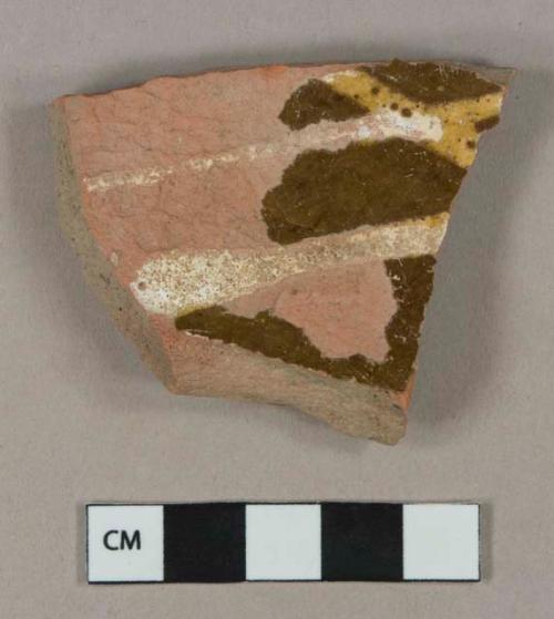 Brown and yellow slip decorated redware vessel body fragment, unglazed exterior