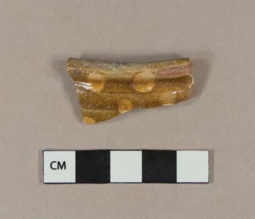 Slip decorated lead glazed redware rim sherd