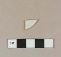 White glazed stoneware rim sherd with incised parallel lines along rim on the interior