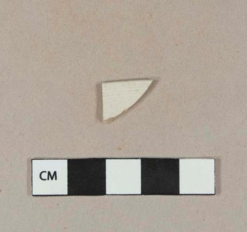 White glazed stoneware rim sherd with incised parallel lines along rim on the interior