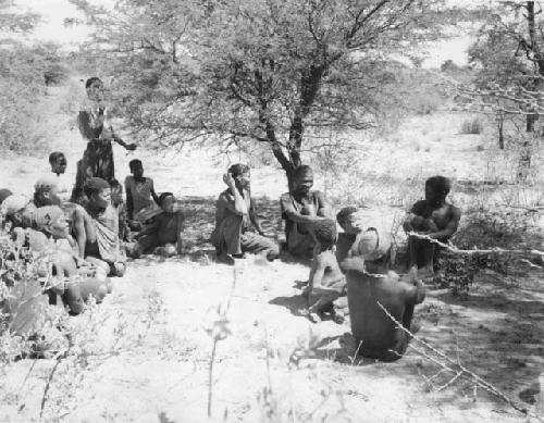 Group of people sitting, with a person standing behind them