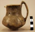 Pottery handled cup with incised design