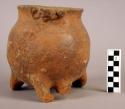 Pottery jar with 3 loop legs and 2 effigy form appliqued at rim.  Brown, probabl