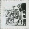 Photograph album, Yaruro fieldwork, p. 11, photo 2, children watching seated man, possibly getting haircut