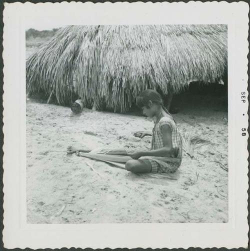 Photograph album, Yaruro fieldwork, p. 27, photo 3, woman working on thatch