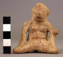 Ceramic figurine, seated human female, perforated