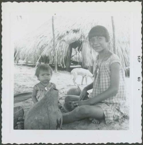 Photograph album, Yaruro fieldwork, p. 44, photo 2, woman and child sitting on the ground