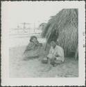 Photograph album, Yaruro fieldwork, p. 45, photo 1, two people sitting outdoors on the ground