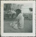 Photograph album, Yaruro fieldwork, p. 47, photo 1, man sitting on the ground with blanket