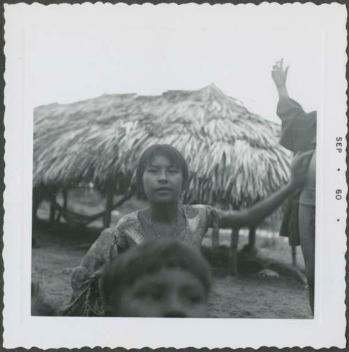 Photograph album, Yaruro fieldwork, p. 52, photo 2, young girl outside thatched building