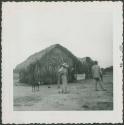 Photograph album, Yaruro fieldwork, p. 66, photo 1, two men and dog in yard