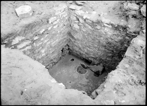 Site 105, Room 7, showing firepit, ventilator shaft and flue, looking north.