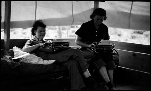 Evelyn and Penny typing in their tent.