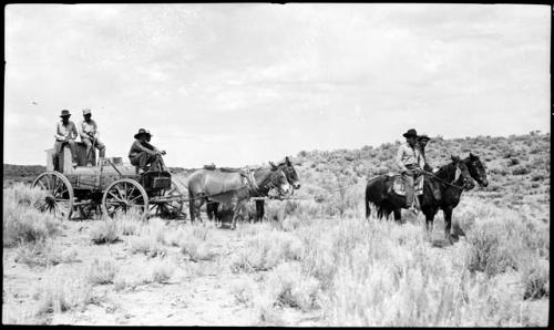 Hopi men driving Everett's wagon