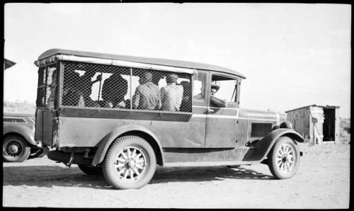 Hopi men in Dodge truck, leaving for work on Awatovi excavations