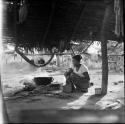 Village, housing, house living: thatched building with woman next to pot