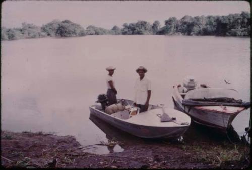 Two men standing on a small white boat