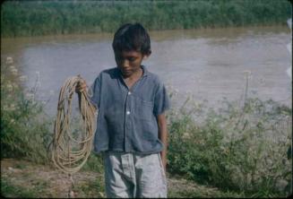 Boy in blue shirt holding rope