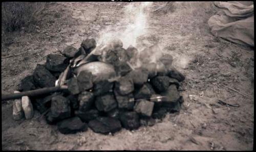 A pot surrounded by hot coals