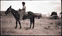 Hopi boy riding a mule