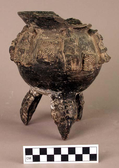 Ceramic tripod jar, moulded human figures, raised incised squares, bird head