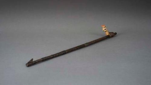 Wooden atlatl with bone figure