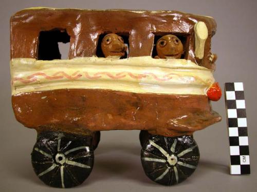 Ceramic polychrome bus with passengers, partially glazed