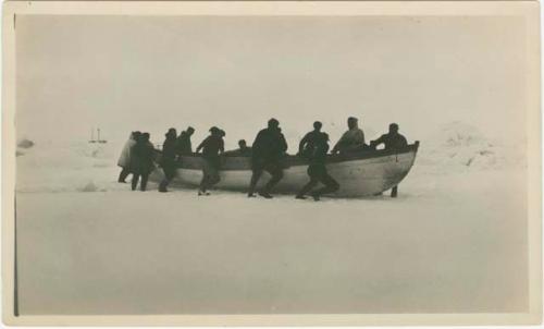 Arctic Voyage of Schooner Polar Bear - Crew pushing boat over snow