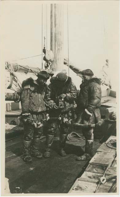 Arctic Voyage of Schooner Polar Bear - Three men on deck, one holding camera