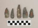 Chipped stone projectile points, including one that is broken into two pieces