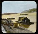 Lantern slide of raft with tent at shore, hand-colored