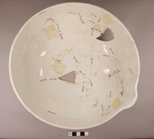 Undecorated porcelain bowl with spout at one side of the rim, unglazed on the exterior; marked with "WEDGEWOOD" on the exterior; fragments crossmend, mended with scotch tape