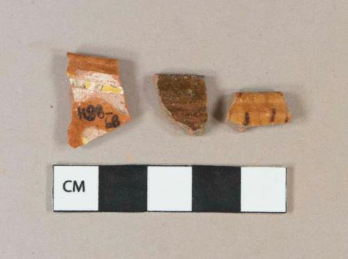 Brown and yellow slip decorated redware vessel rim fragments