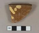 Yellow and browl slip decorated redware vessel rim fragment