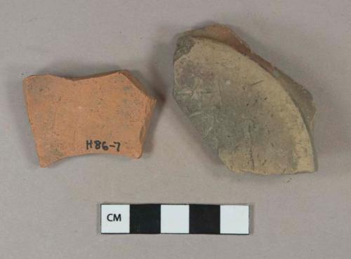 brown lead glazed redware vessel base fragments, 1 fragment heavily burned, both incised on base