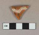 Yellow on red slip decorated redware vessel rim fragment