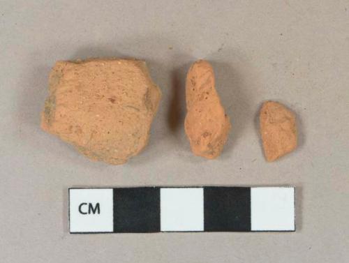 Light orange brick fragments, heavily degraded