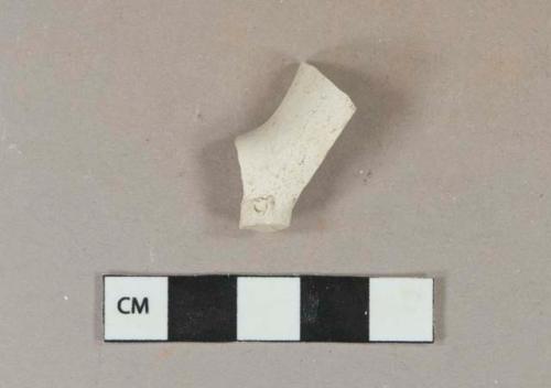 White kaolin pipe bowl fragment with foot, "T" and "D" molded on either side of foot, 5/64" bore diameter