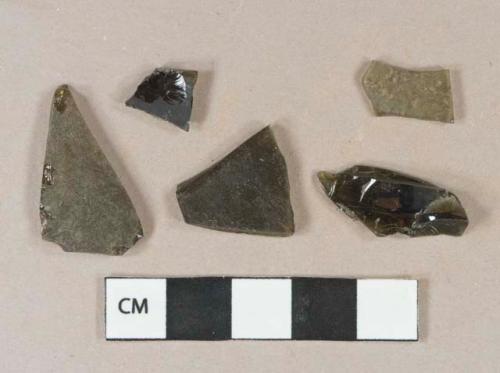 Dark olive green vessel body fragment, likely bottle glass