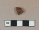 Dark brown lustrous salt glazed stoneware vessel rim fragment, dark gray-brown paste, likely Nottingham type