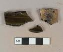 Dark olive green vessel glass fragments, likely bottle glass, 1 fragment heavily patinated