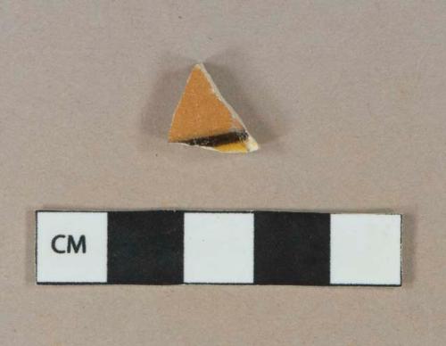 Yellow, black, and orange lead glazd exterior, white lead glazed interior earthenware vessel body fragment, white paste, likely Mochaware