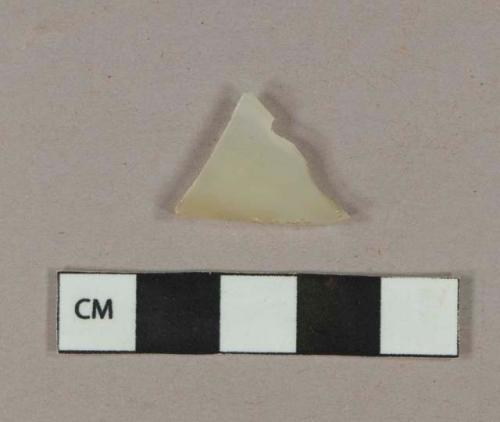 Yellowish, semi-opaque flat glass fragment, one side textured