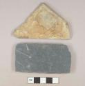 Two stone fragments, 1 dark gray slate fragment, rectanglar shaped, 1 mudstone fragment with remains of mortar on one side