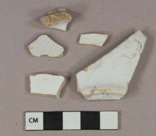 2 white undecorated tin-glazed earthenware vessel body fragments, buff paste; 2 white undecorated pearlware vessel body fragments, white paste; 1 white undecorated ironstone vessel base fragment, white paste