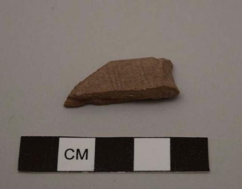 Decorated fragment of a sickle blade haft, grooved on side, incised ornament on upper surface